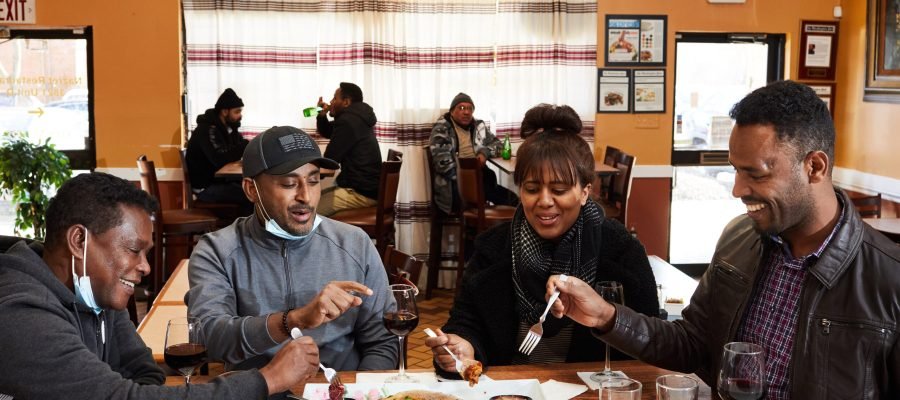 FALLS CHURCH, VA - JANUARY 30: From left to right: Admassu Mekonnen, Wubeshet Mehari, Milka Tesfaye and Deriba Reba share lunch at Nazret Ethiopian restaurant photographed in Falls Church, VA on January, 30, 2021. More people are eating Ethiopian food with forks due to Covid. (Photo by Deb Lindsey for The Washington Post).